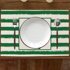 Vue détaillée d'un set de table en lin à rayures vertes et blanches sur table bois