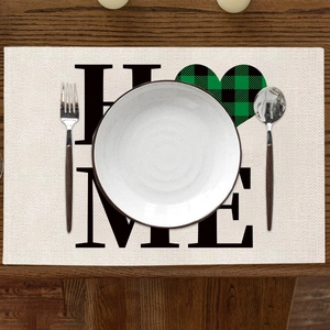 Détail du set de table en lin avec texte Home et motif de cœur à carreaux verts et noirs