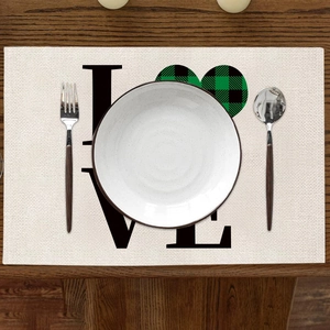 Détail d'un set de table en lin avec texte LOVE et motif cœur à carreaux verts