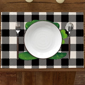 Détail du set de table en lin à carreaux avec motif trèfle vert sur table en bois