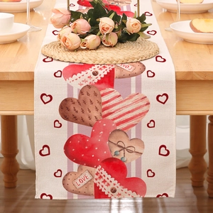Detail eines Valentinstag-Tischläufers mit roten Herzen und Spitze auf einem Holztisch