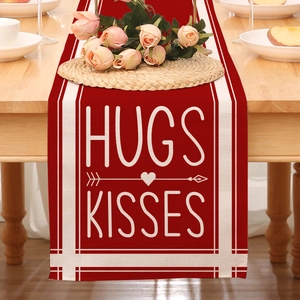 Detail eines roten Valentinstag Tischläufers mit Hugs Kisses Aufdruck und Herz Pfeil Motiv