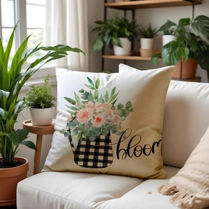 Floral linen pillow case with bloom print and black plaid kettle on white sofa