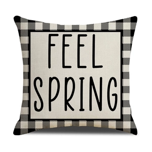 Close-up of linen pillow cover with Feel Spring text and buffalo check borders