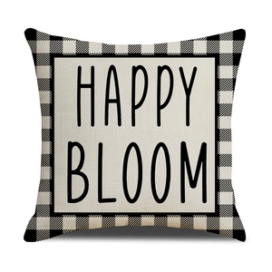 Close-up of linen pillow cover with black and white buffalo check and Happy Bloom text