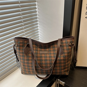 Classic checkered large capacity tote bag with leather handles on a white window sill