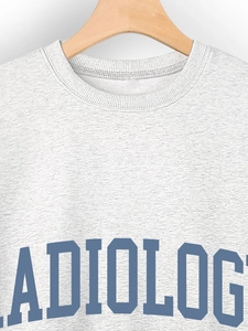 Detail of grey crewneck sweatshirt with dark blue RADIOLOG lettering on a wooden hanger