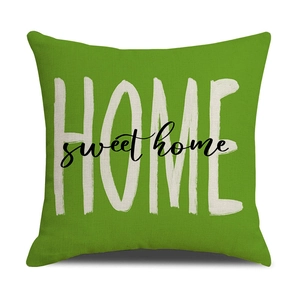 Détail de la housse de coussin verte avec texte HOME sur tissu texturé épais
