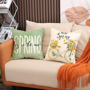 Detailed view of linen cushion covers featuring green spring theme floral patterns and bike art