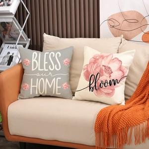 Détail de deux housses de coussin en lin à fleurs avec imprimés Bless our Home et Bloom