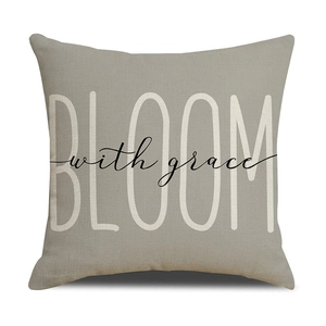 Close-up of BLOOM with grace typography on taupe linen texture sofa cushion cover