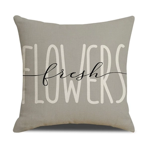 Detail of taupe linen square pillowcase with fresh FLOWERS printed text on white background