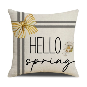 Close-up of HELLO spring daisy print and yellow bow on off-white linen pillowcase