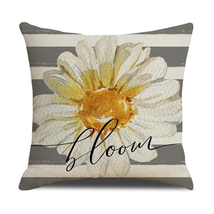 Detail of square pillow cover with daisy print and artistic bloom text on striped fabric