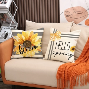 Detail of linen sunflower pillows with bloom and hello spring text on a sofa