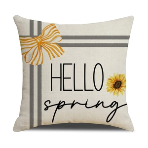 Detail of linen pillow cover with Hello Spring text and bright sunflower design