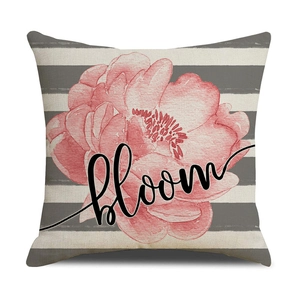 Close-up of linen cushion cover with sunflower pattern, stripes, and Bloom text