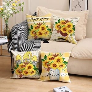 Lot de quatre housses de coussin tournesol et gnome sur un canapé beige chic