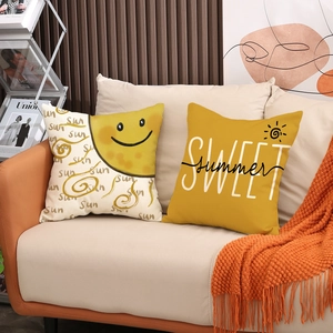 Linen cushion covers set with yellow sun and summer prints on a cozy sofa