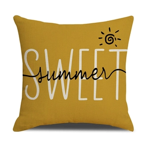 Detail of yellow linen pillowcase featuring bold SWEET summer print and sun motif