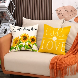 Linen pillow covers with sunflower print and hello LOVE text on a cozy beige sofa