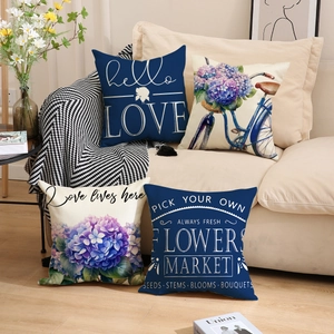 Close-up of linen pillow covers with bicycle and floral prints on a beige sofa