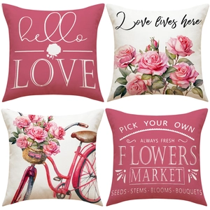 Detail of four linen pillow covers with red floral bicycle and romantic love text designs