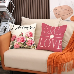 Close-up of minimalist linen pillow covers with rose prints and Love lives here text