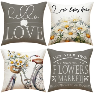 Detail of four linen pillowcases with daisy patterns and rustic bicycle prints
