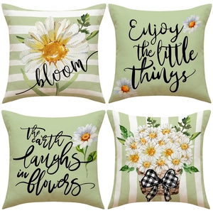 Detailed view of four linen pillow covers featuring sage green daisies and patterns