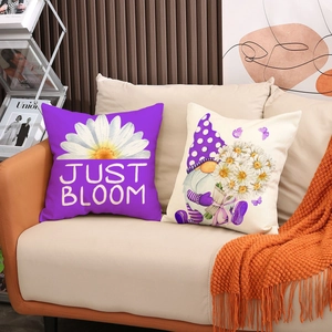 Detail of linen pillow covers with gnome and daisy print on a modern fabric sofa