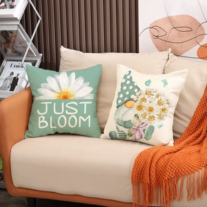 Detailed close-up of linen pillow covers with daisy and gnome patterns on a modern sofa