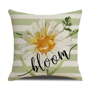 Detail of linen pillowcase with green stripes, a large daisy, and bloom lettering