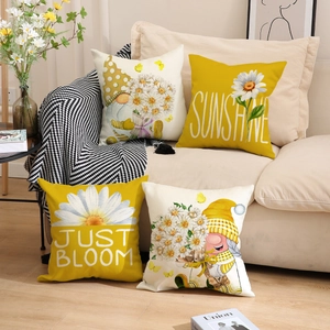 Close-up of four spring-themed decorative linen pillowcases with daisy and gnome patterns