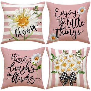 Close-up of 4-piece linen pillow covers with daisy illustrations and pink stripe patterns