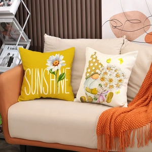 Detail of linen pillow covers with sunflower and gnome prints on a cozy modern sofa