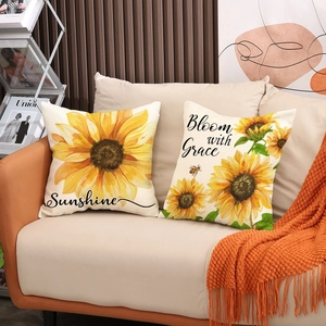Detailed view of sunflower pillow covers with Sunshine and Bloom with Grace text on sofa