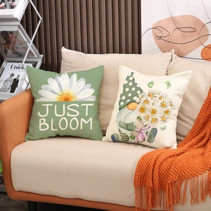 Detail view of linen pillows with gnome print and floral pattern on a cozy modern sofa