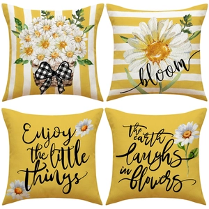 Detail of four yellow daisy cushion covers with floral prints and motivational quotes