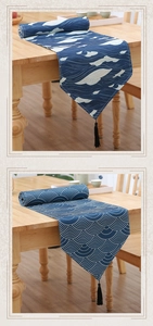 Detailed view of wave and scale patterns on navy blue fabric with black tassels