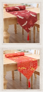 Detail of red table runners with crane and cloud patterns featuring red velvet tassels