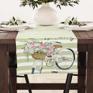 Detail des grün-weiß gestreiften Leinen-Tischläufers mit Hello Spring Fahrrad-Druck