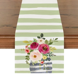 Detailansicht eines Leinentischläufers mit Aquarell-Blumenmuster und grünen Streifen