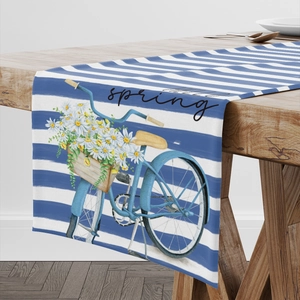 Detail eines Leinentischläufers mit blauen Streifen, Blumenfahrrad und Hello Spring Text