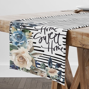Detail eines gestreiften Tischläufers mit floralem Print und Home Sweet Home Schriftzug