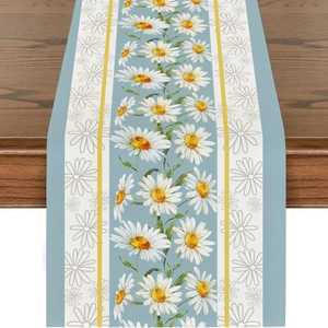 Makroaufnahme von Leinentischläufer mit blauen Streifen und Gänseblümchen-Print auf Holz