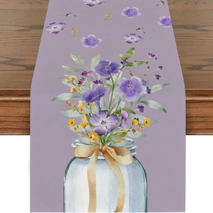 Detail eines Tischläufers mit Aquarellblumen und Lavendelmuster auf dunklem Holztisch