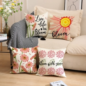 Detail of four linen cushion covers with floral daisy prints and cursive typography
