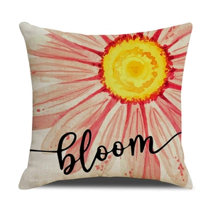 Detailed view of watercolor floral daisy print and 'bloom' lettering on linen pillow cover