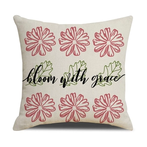 Detail of linen pillowcase with daisy floral print and 'bloom with grace' text